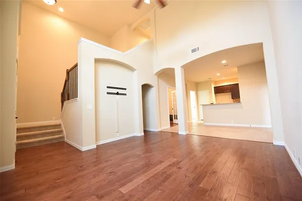 a view of a big room with wooden floor and windows
