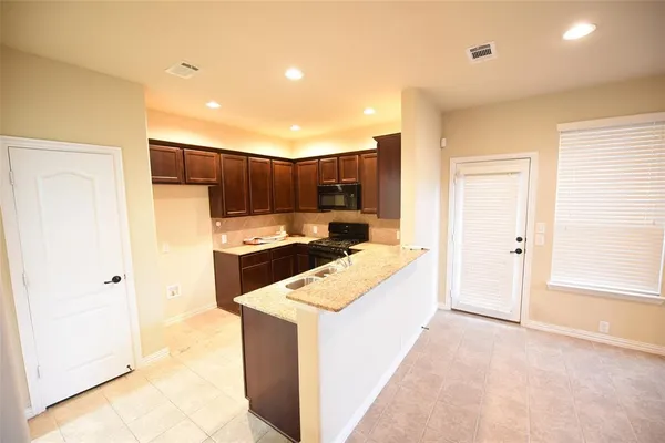 a kitchen with a refrigerator sink and cabinets