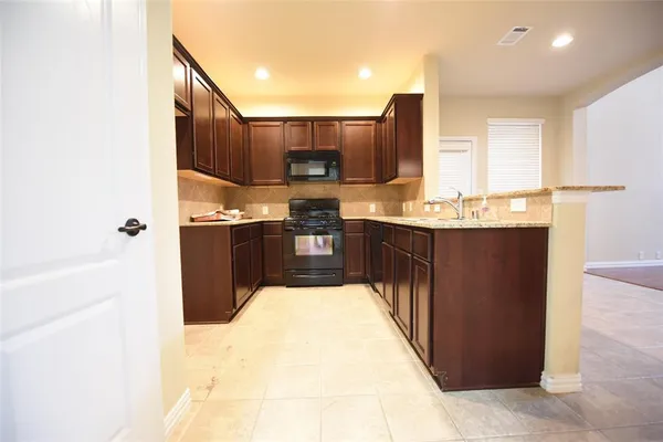 a kitchen with stainless steel appliances kitchen island granite countertop a sink and cabinets