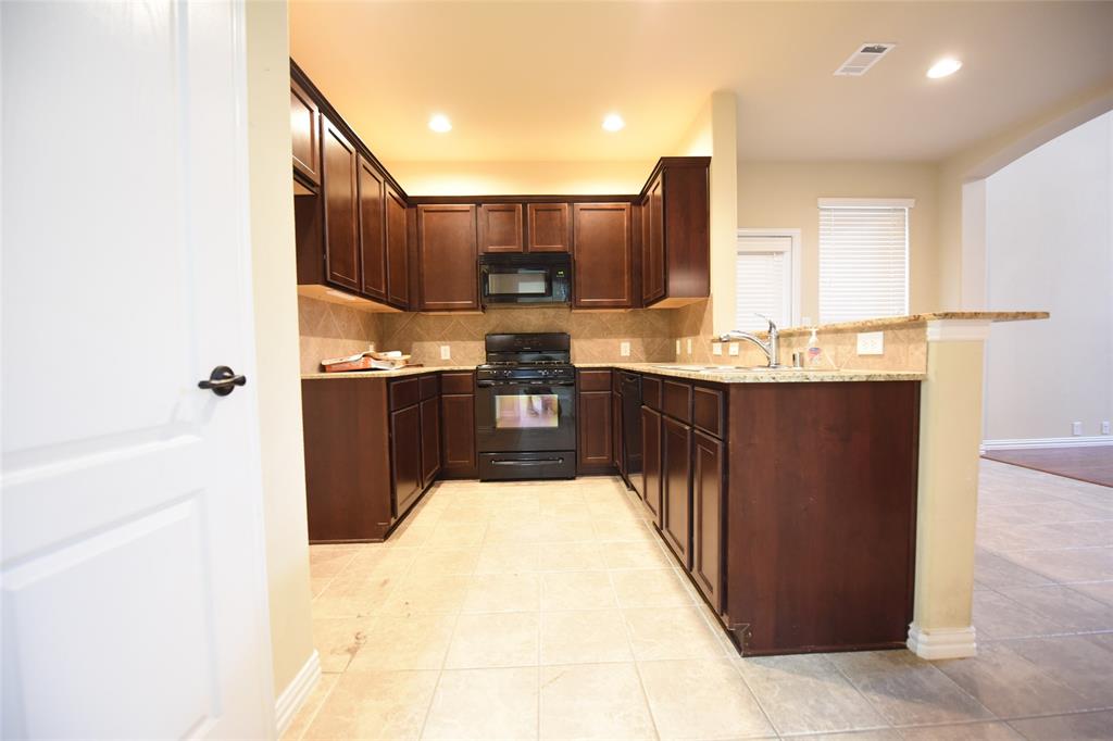 855 Llano Drive Allen, TX 75013 - Photo 6 of 20 a kitchen with stainless steel appliances kitchen island granite countertop a sink and cabinets