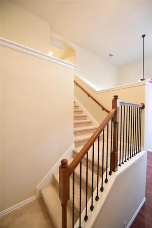 a view of staircase with railing and white walls