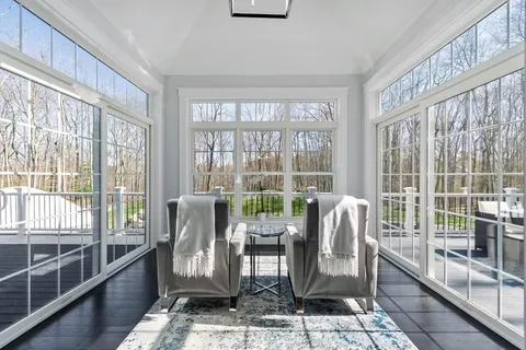 a dining room with furniture water view and a floor to ceiling window