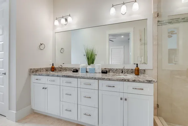 a bathroom with a granite countertop sink double and mirror