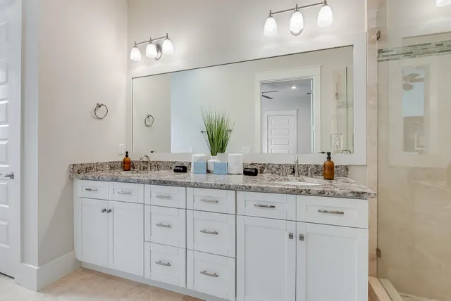 a bathroom with a granite countertop sink double and mirror