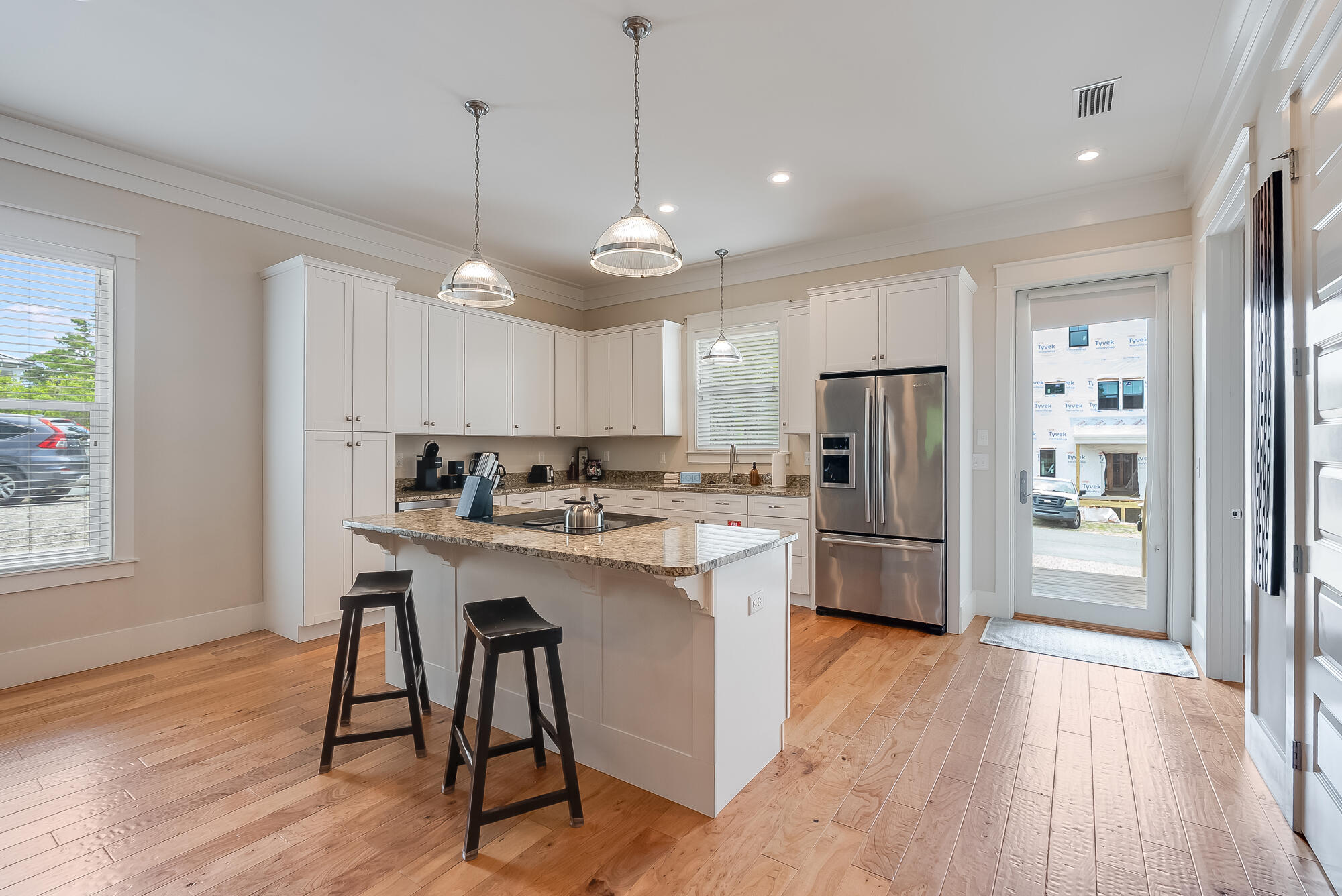 45 Pine Knoll Santa Rosa Beach, FL 32459 - Photo 2 of 24 a kitchen with stainless steel appliances a refrigerator a stove a sink dishwasher and a dining table with wooden floor