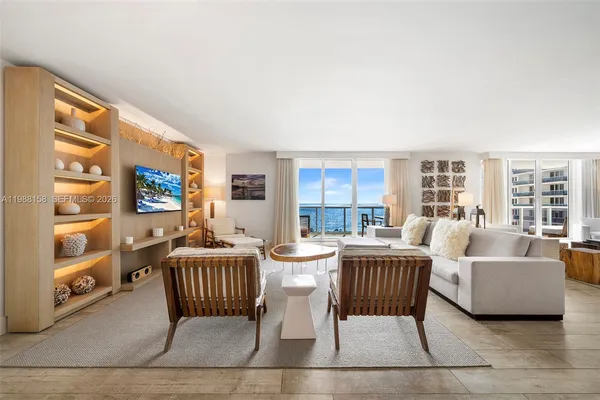 a living room with couches a coffee table and a large window with outer view