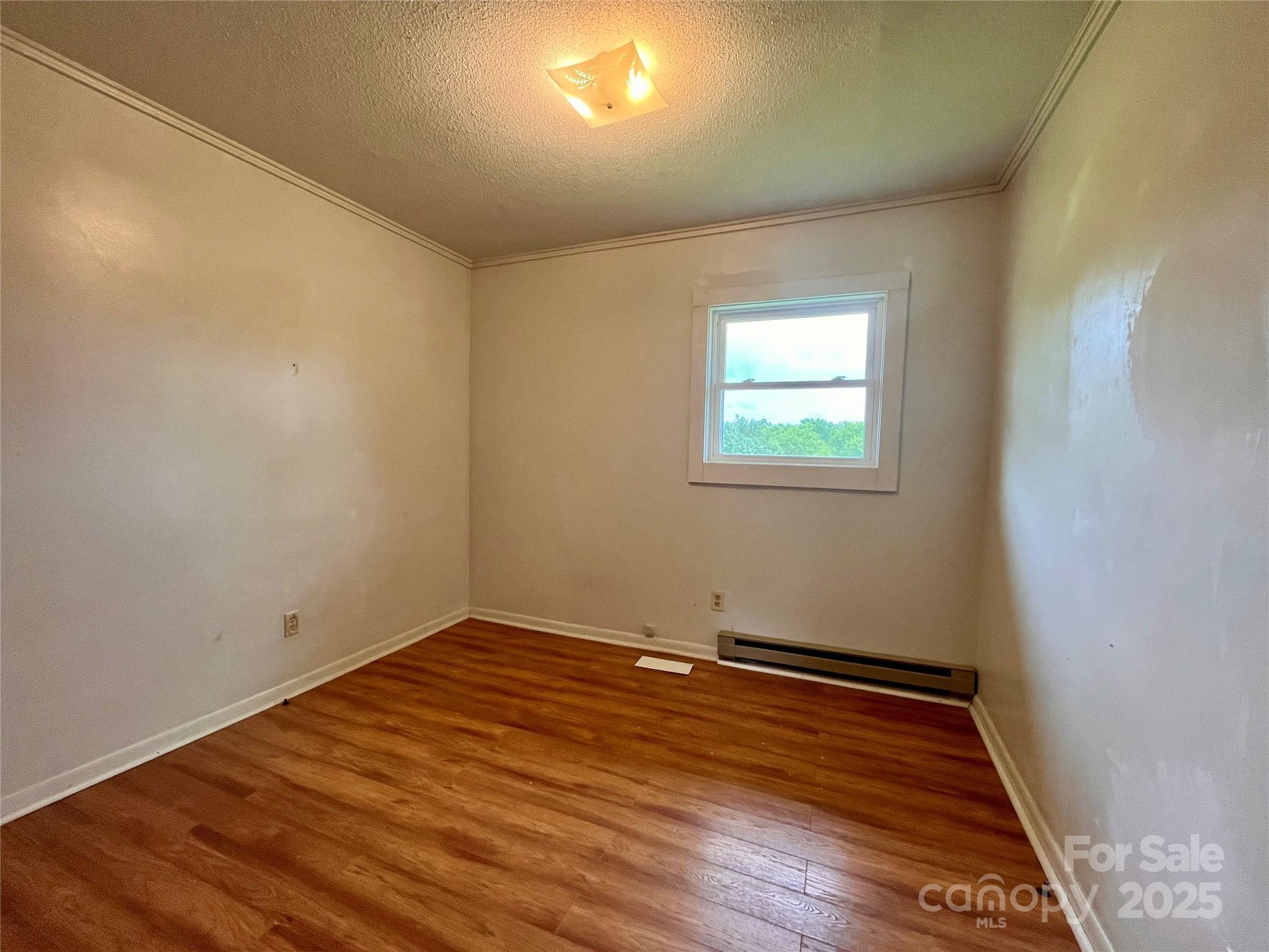 657 Arrowhead Trail Marion, NC 28752 - Photo 14 of 22 an empty room with wooden floor and windows