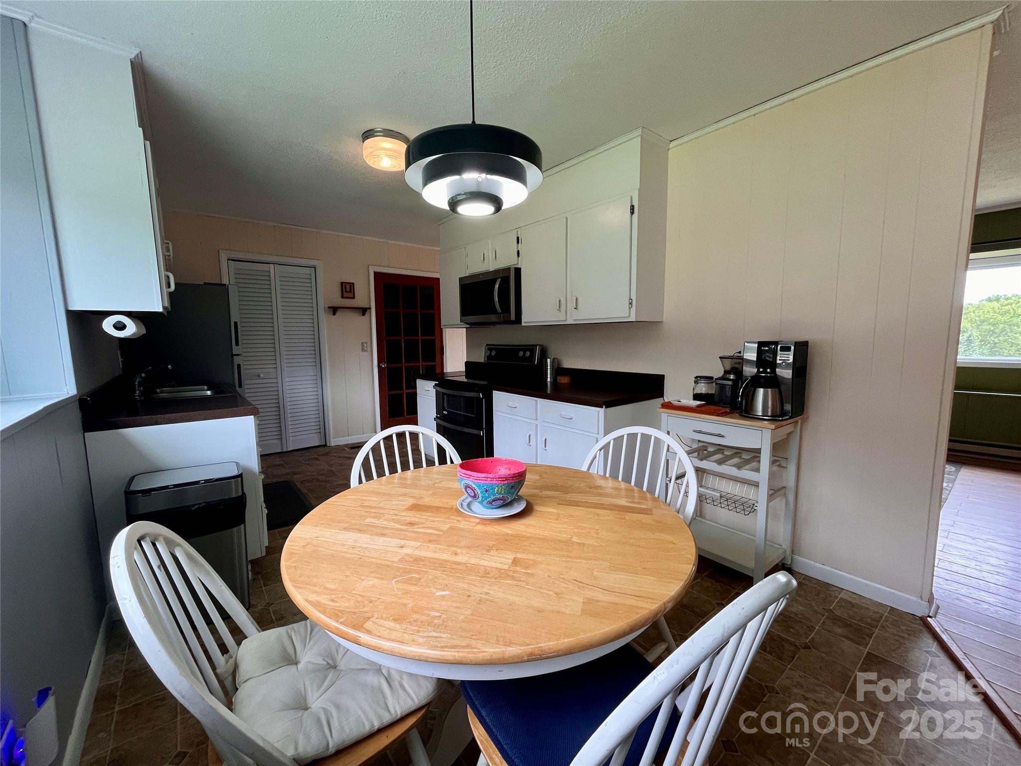 657 Arrowhead Trail Marion, NC 28752 - Photo 9 of 22 a kitchen with stainless steel appliances kitchen island granite countertop a dining table chairs and a refrigerator