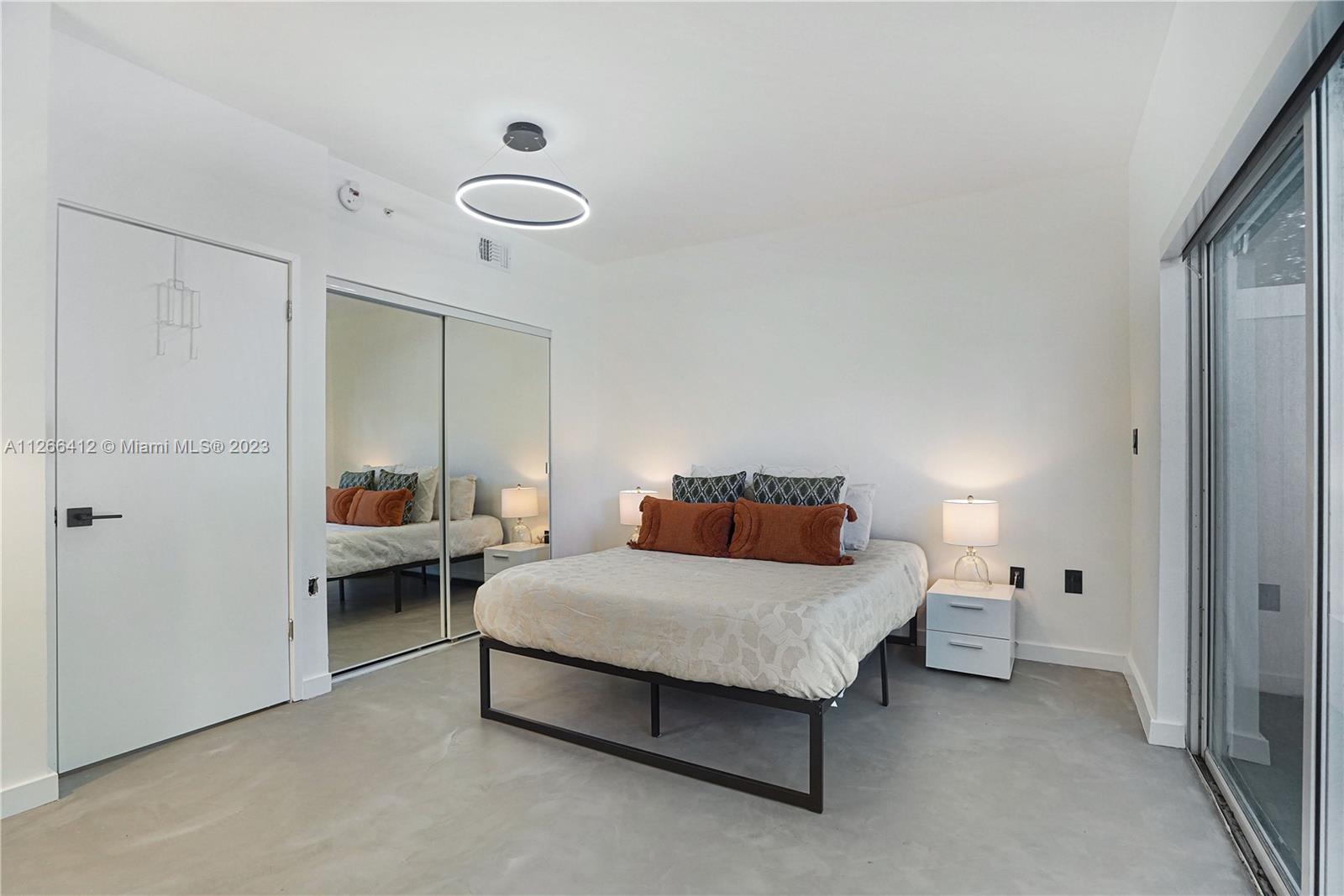 123 Southwest 17th Road, Unit 104 Miami, FL 33129 - Photo 11 of 34 a bedroom with a bed and a chandelier