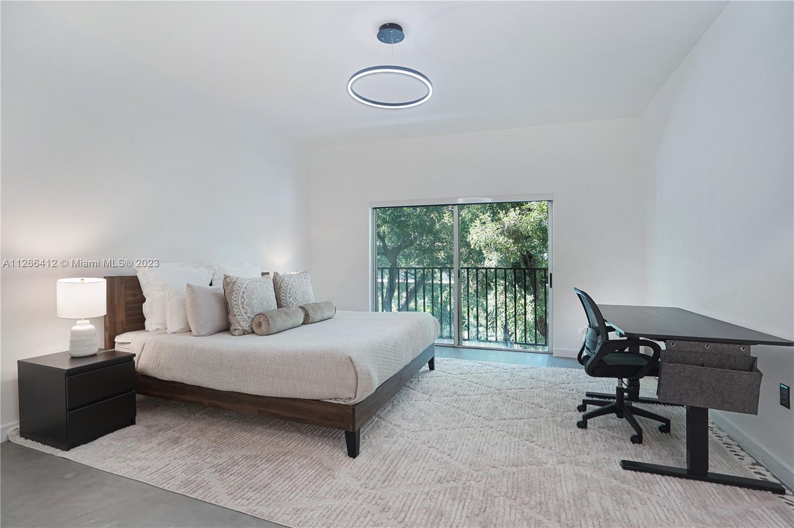 123 Southwest 17th Road, Unit 104 Miami, FL 33129 - Photo 17 of 34 a bedroom with a bed a lamp and a window