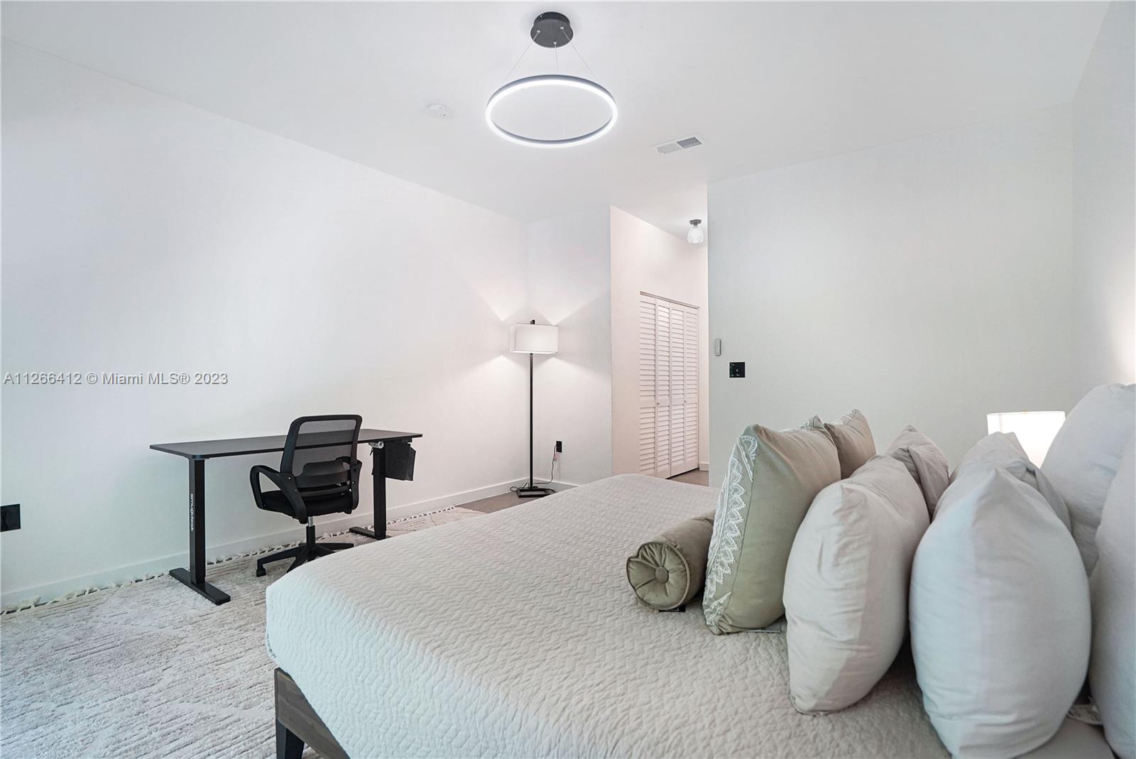 123 Southwest 17th Road, Unit 104 Miami, FL 33129 - Photo 22 of 34 a bedroom with a bed and chair