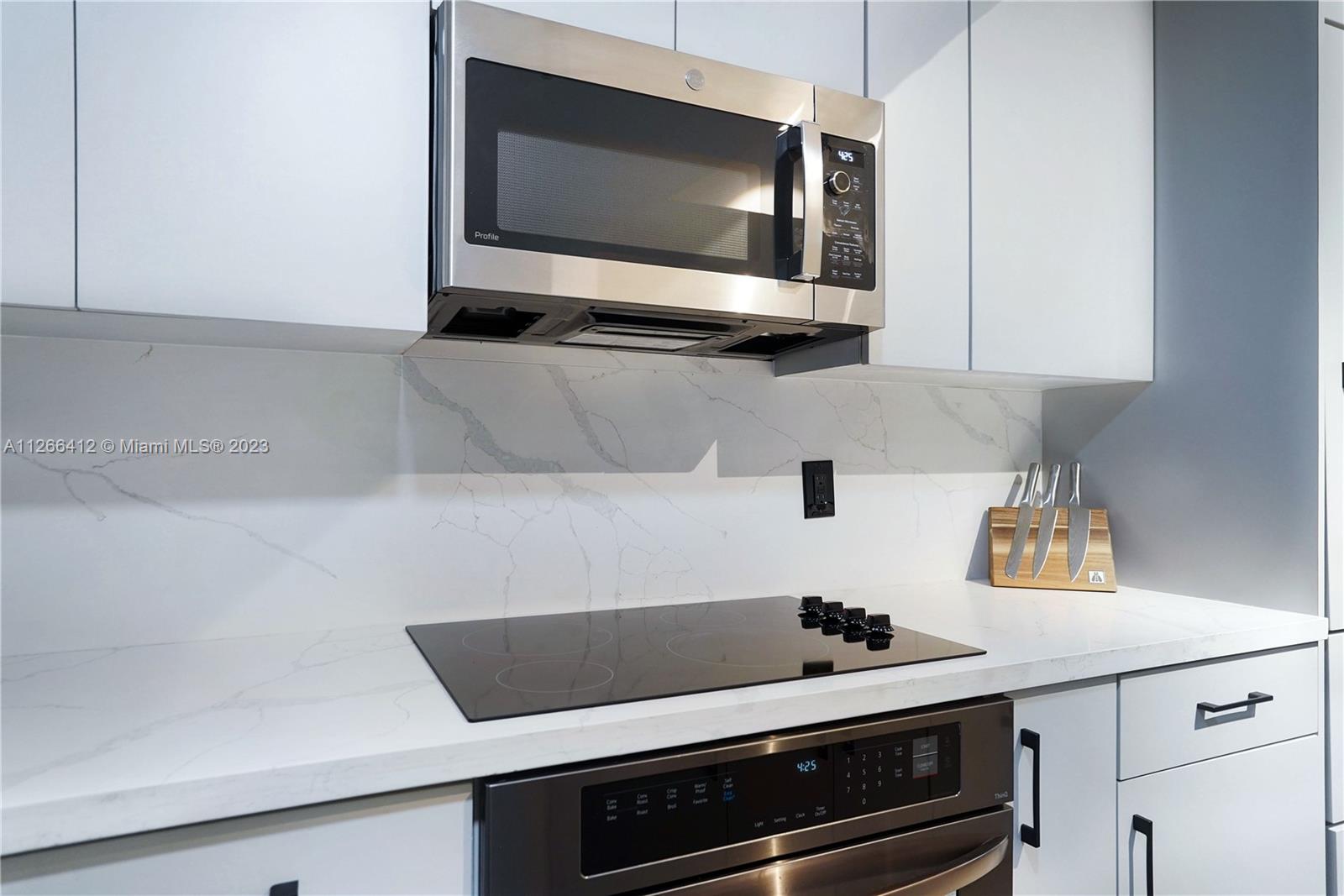 123 Southwest 17th Road, Unit 104 Miami, FL 33129 - Photo 4 of 34 a kitchen with a stove and a microwave