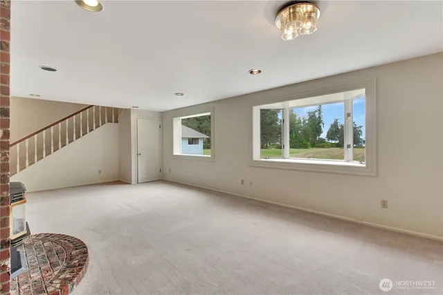 a view of staircase with lots of frames on wall and a window