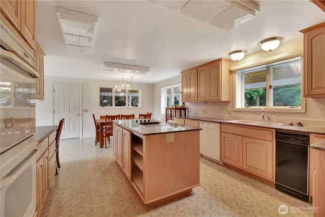 a kitchen with granite countertop a sink stove and refrigerator