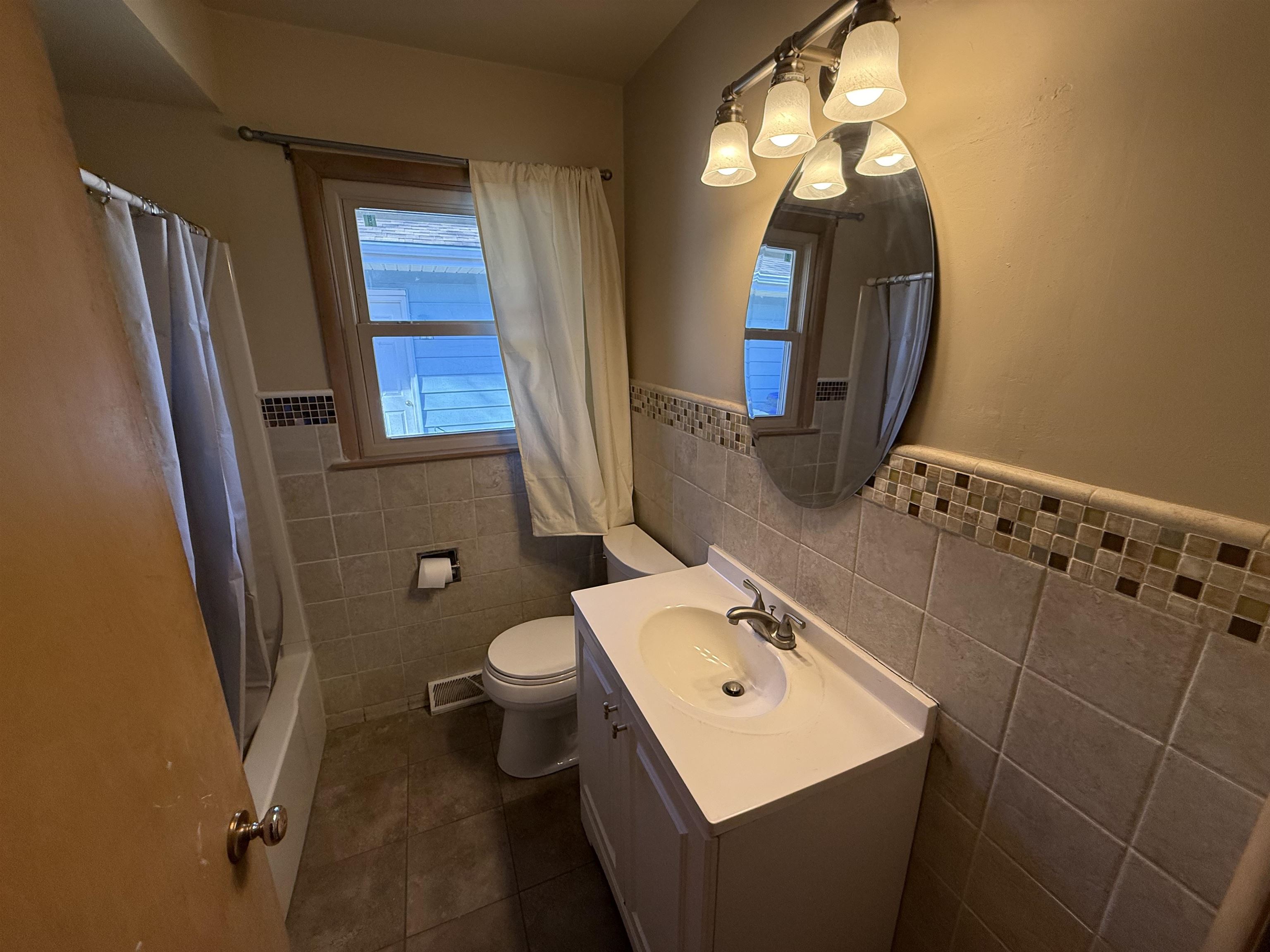 4524 Newcastle Road Rockford, IL 61108 - Photo 12 of 24 a bathroom with a sink toilet and mirror
