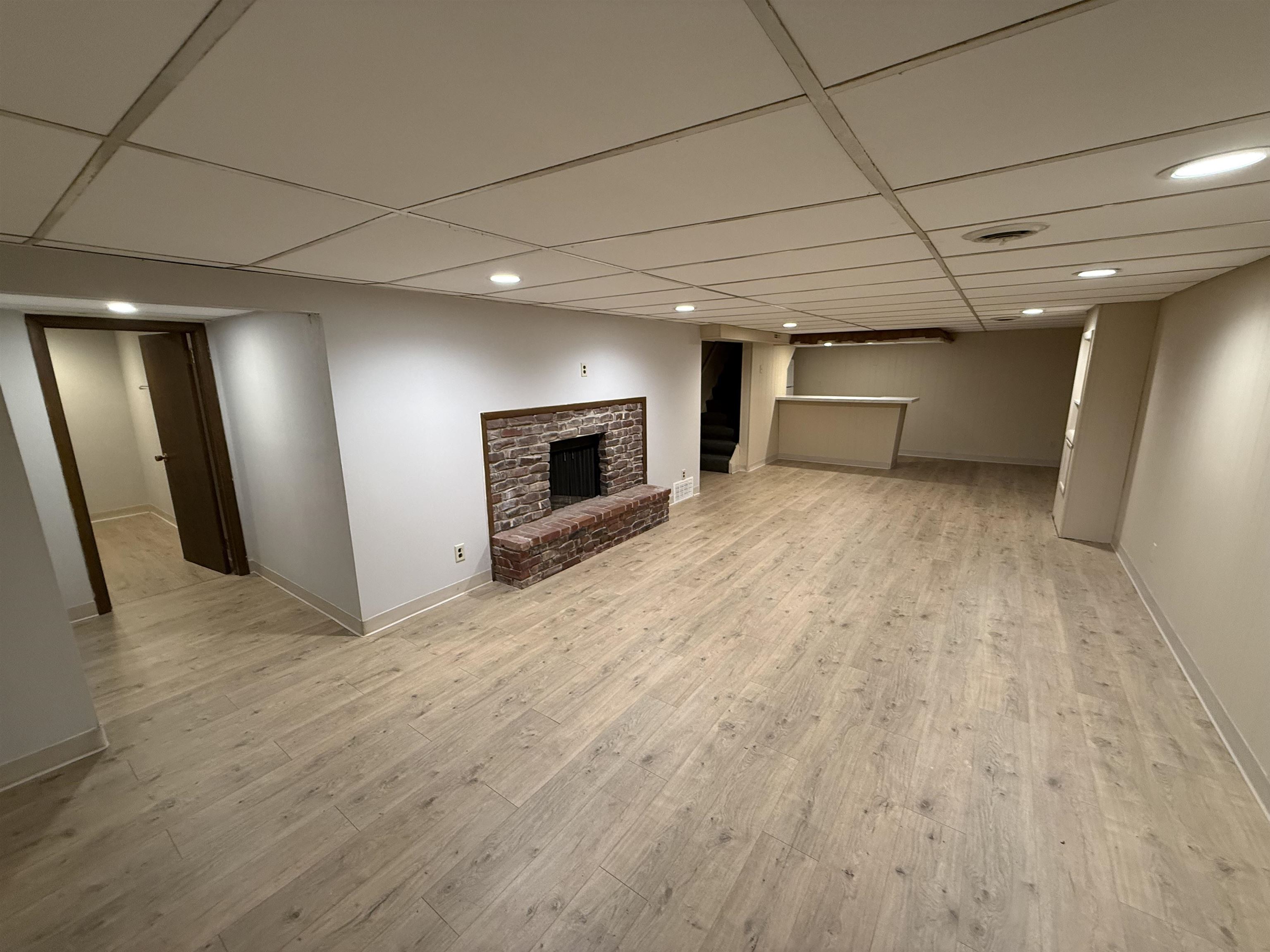 4524 Newcastle Road Rockford, IL 61108 - Photo 17 of 24 an empty room with wooden floor and fireplace