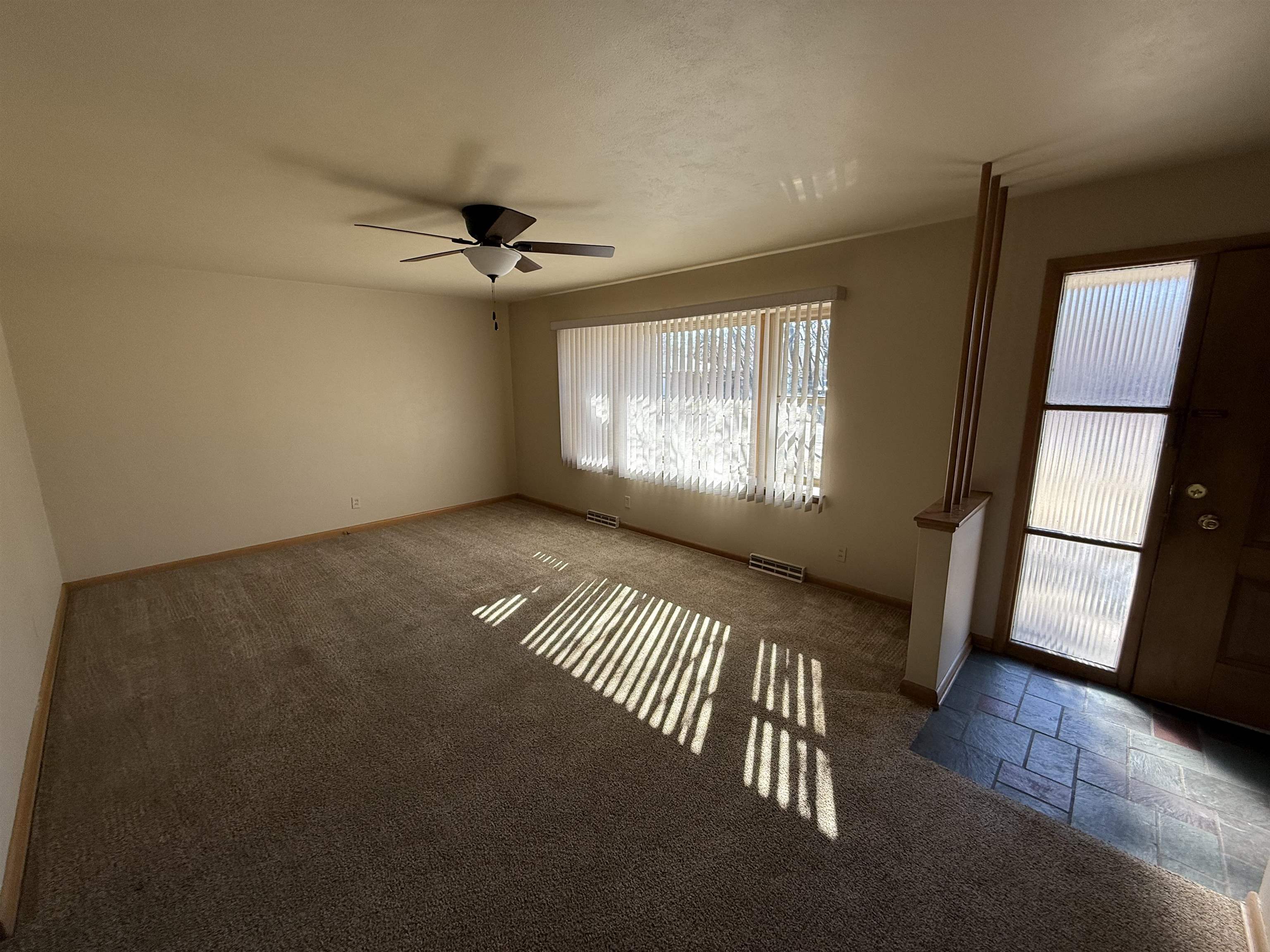 4524 Newcastle Road Rockford, IL 61108 - Photo 3 of 24 an empty room with windows and stairs