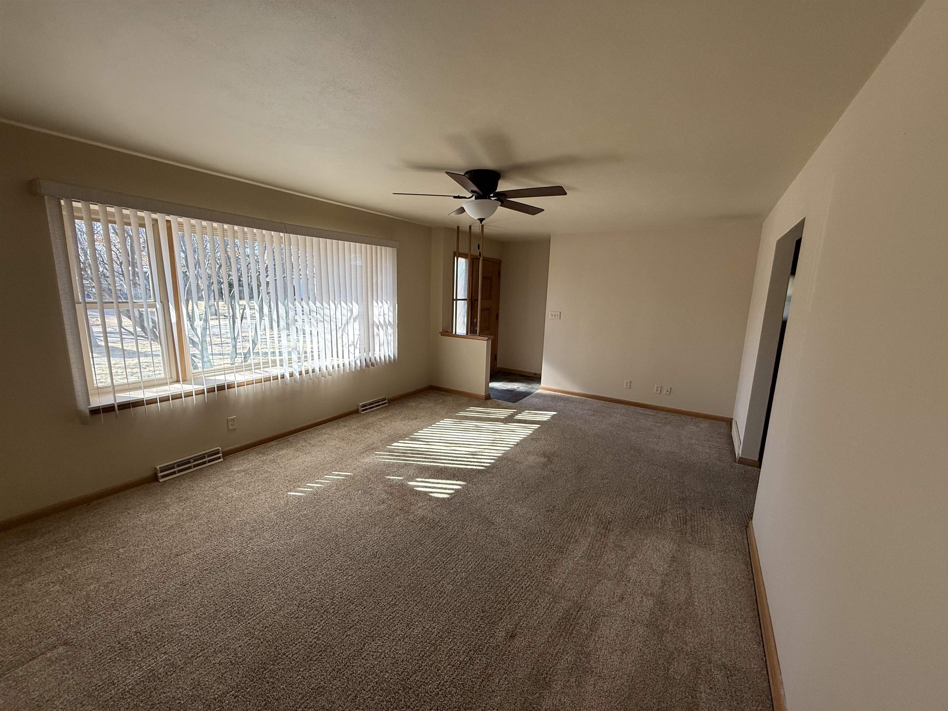 4524 Newcastle Road Rockford, IL 61108 - Photo 4 of 24 an empty room with windows and fan