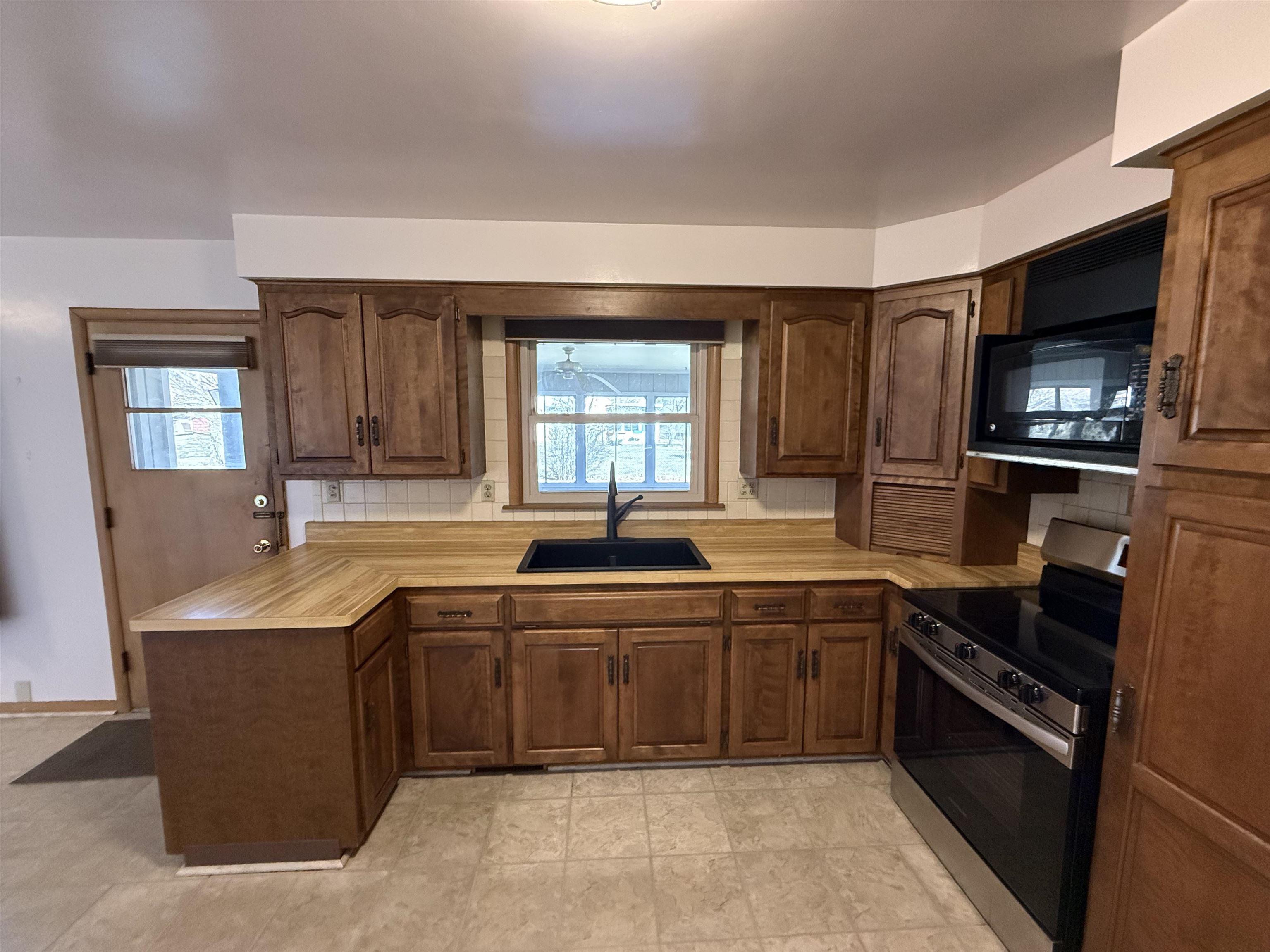 4524 Newcastle Road Rockford, IL 61108 - Photo 5 of 24 a kitchen with a sink stove and microwave