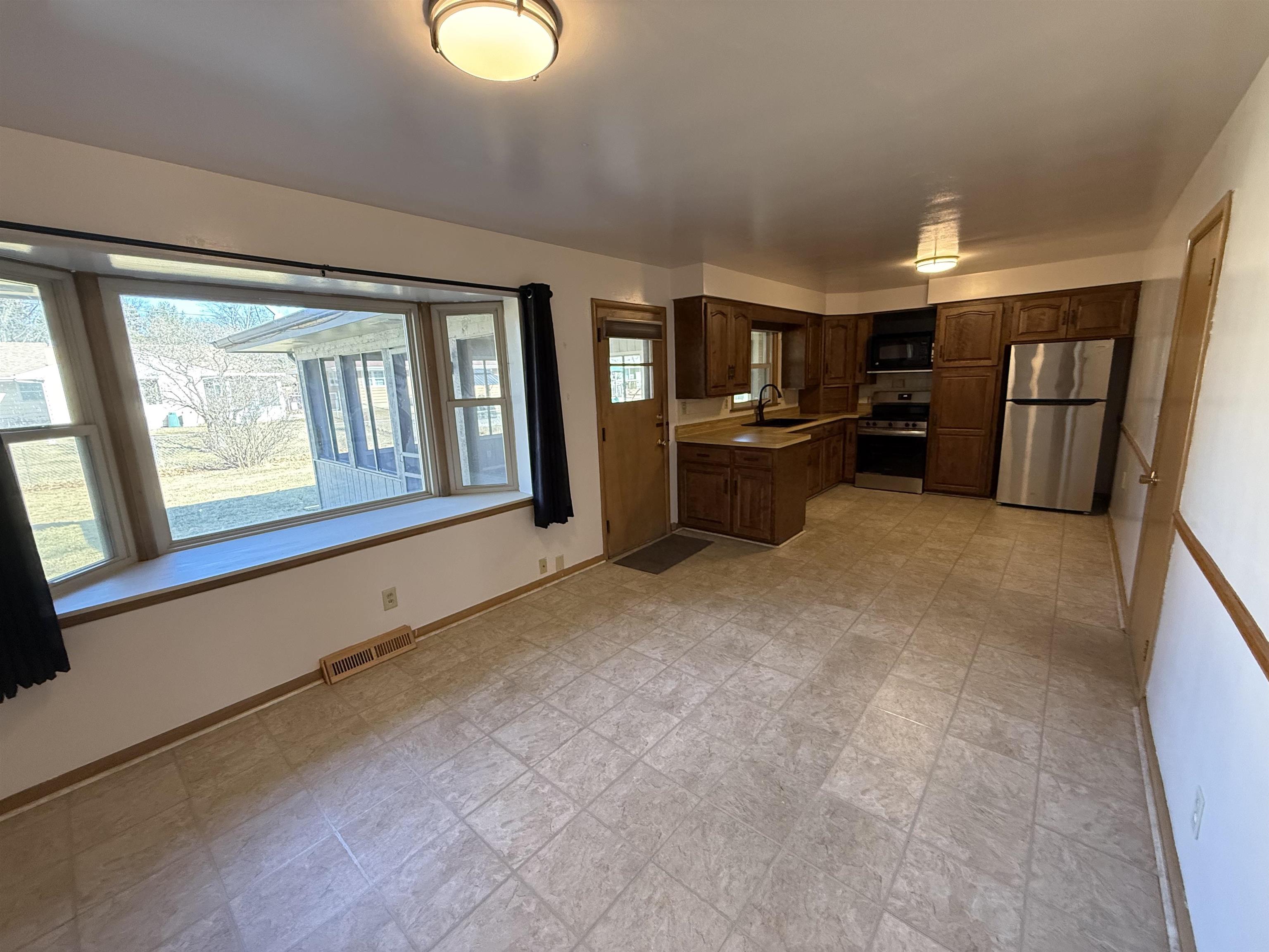 4524 Newcastle Road Rockford, IL 61108 - Photo 6 of 24 a view of an empty room with window and kitchen view
