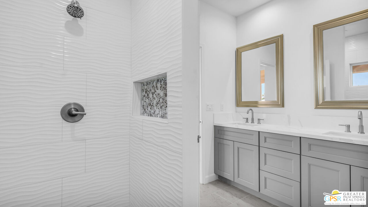 7160 Olympic Road Joshua Tree, CA 92252 - Photo 21 of 58 a bathroom with a double vanity sink a mirror and a shower