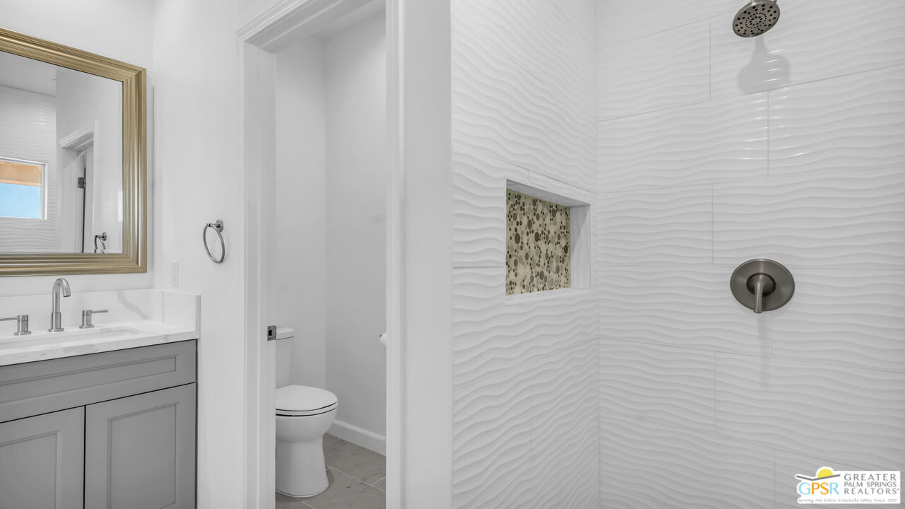 7160 Olympic Road Joshua Tree, CA 92252 - Photo 22 of 58 a bathroom with a granite countertop toilet sink and mirror