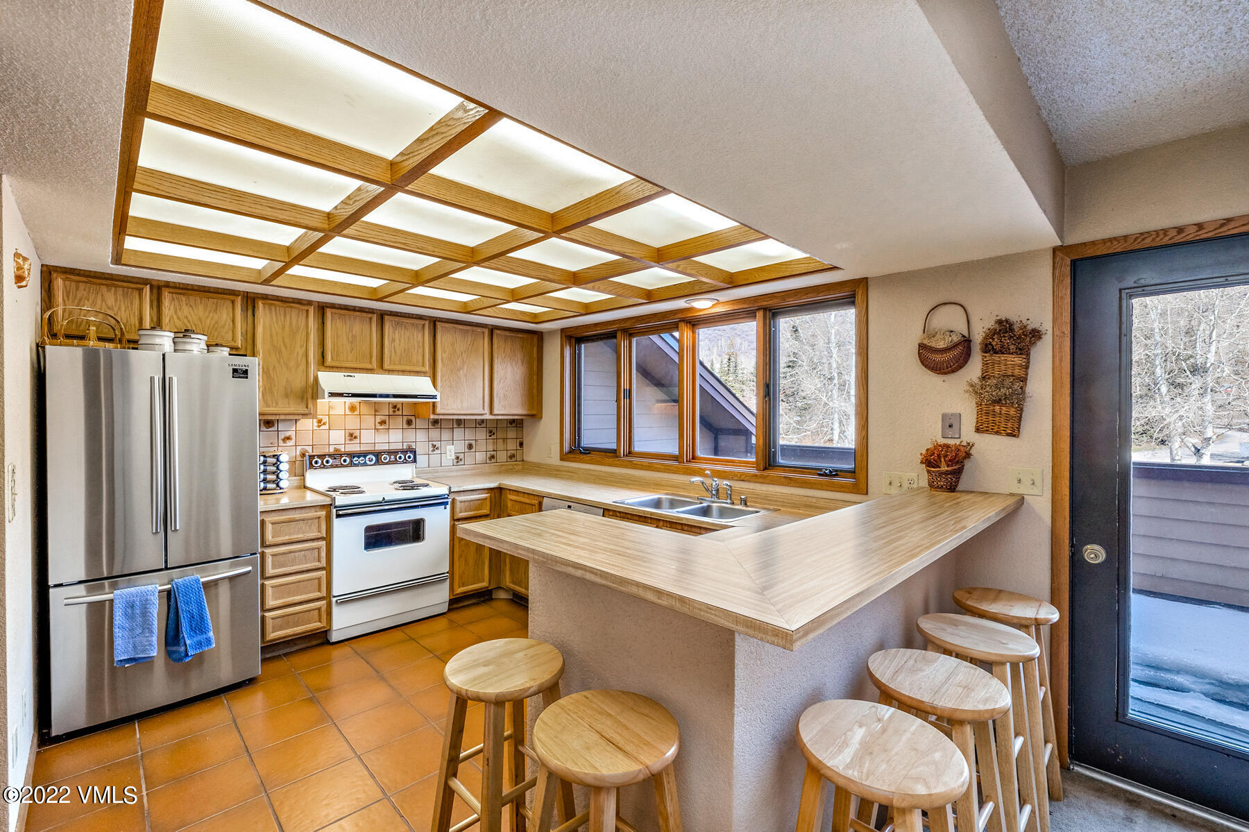 1750 South Frontage Road West, Unit E3 Vail, CO 81657 - Photo 11 of 39 a kitchen with a stove a refrigerator and a dining table