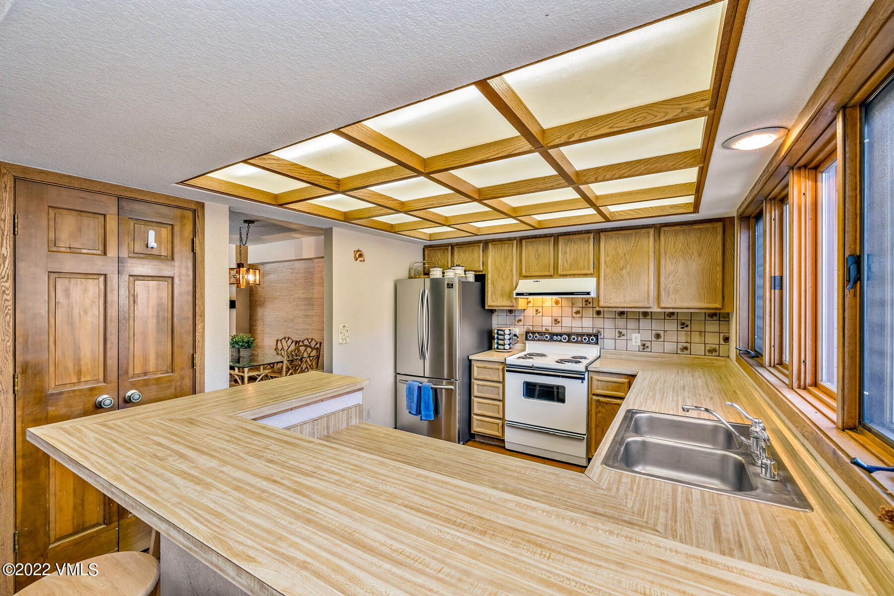 1750 South Frontage Road West, Unit E3 Vail, CO 81657 - Photo 14 of 39 a kitchen with stainless steel appliances kitchen island granite countertop a stove and a wooden floors