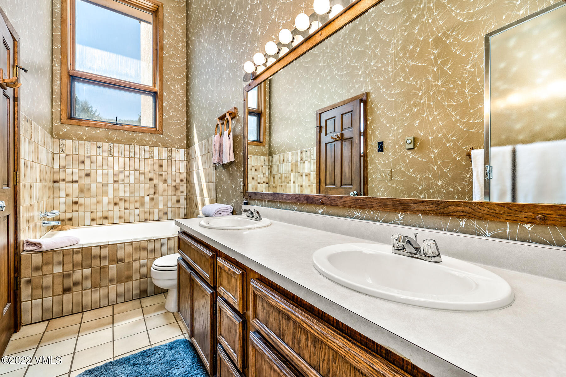 1750 South Frontage Road West, Unit E3 Vail, CO 81657 - Photo 19 of 39 a bathroom with a granite countertop sink a large mirror and a bathtub
