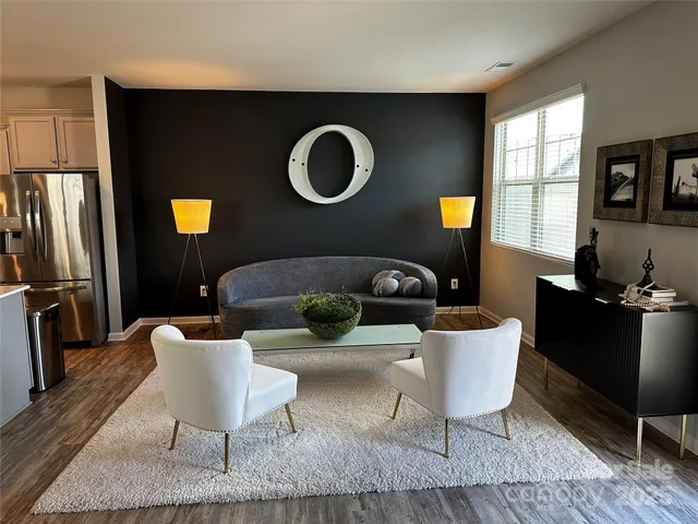 a living room with lots of furniture and kitchen view