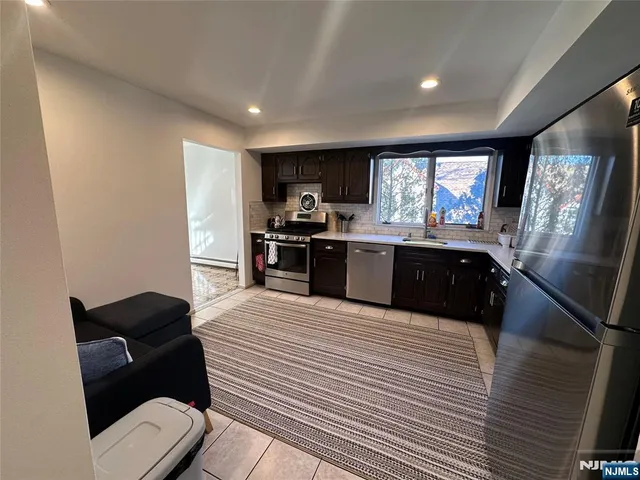 a large kitchen with stainless steel appliances kitchen island granite countertop a sink and cabinets
