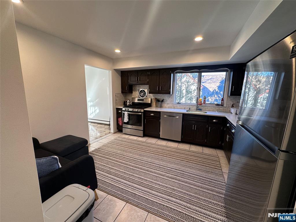 531 Day Avenue, Unit 1 Ridgefield, NJ 07657 - Photo 8 of 20 a large kitchen with stainless steel appliances kitchen island granite countertop a sink and cabinets