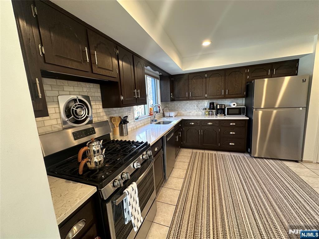 531 Day Avenue, Unit 1 Ridgefield, NJ 07657 - Photo 9 of 20 a kitchen with stainless steel appliances granite countertop a refrigerator and a stove top oven