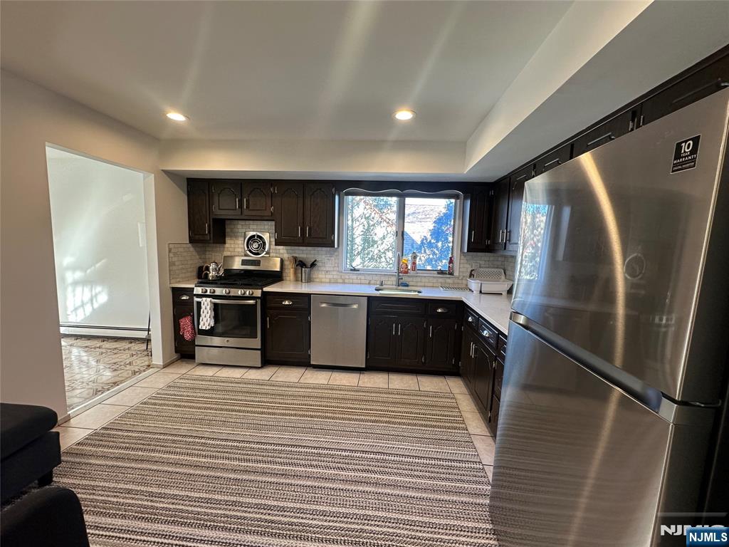 531 Day Avenue, Unit 1 Ridgefield, NJ 07657 - Photo 10 of 20 a large kitchen with a sink a refrigerator and a stove top oven