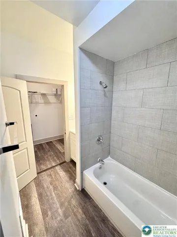 a bathroom with a tub a sink a window and a shower