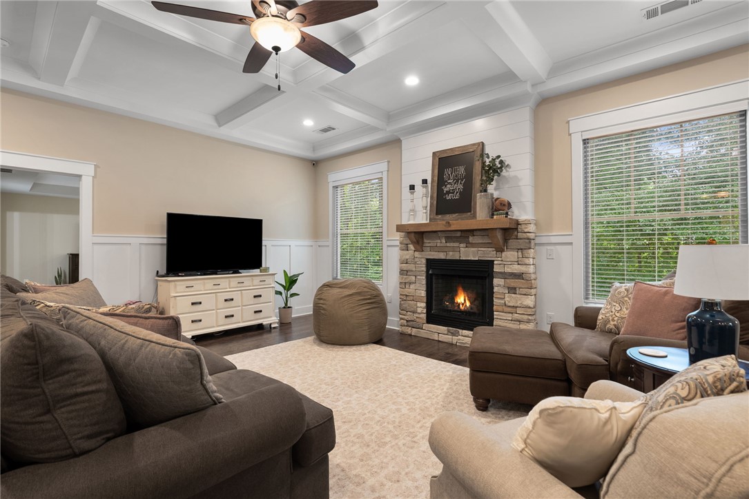 201 Hearthstone Drive Anderson, SC 29621 - Photo 11 of 49 A comforting living area boasts a stone-faced fireplace, coffered ceilings, and warm wood flooring.