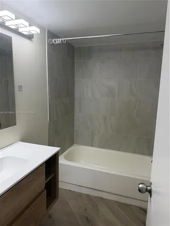 a bathroom with a sink a mirror and a bathtub