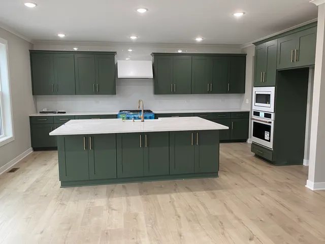 a kitchen with kitchen island sink refrigerator and microwave