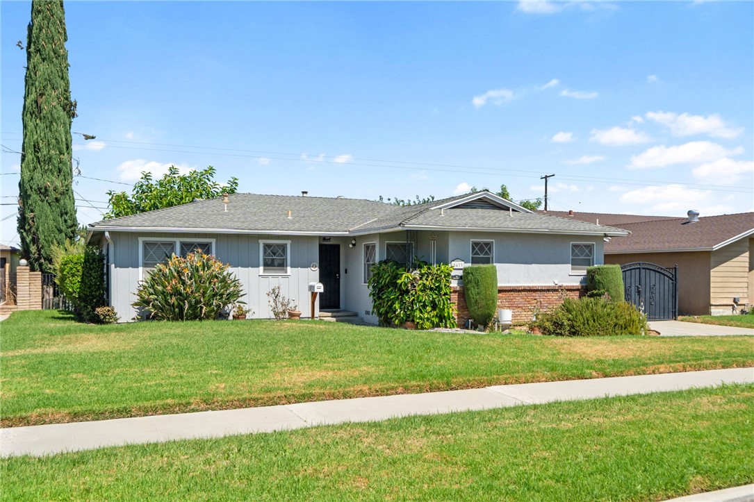 5433 Rochester Street Riverside, CA 92504 - Photo 3 of 29 Wide front view of the home with a grassy lawn and landscaped entry area.