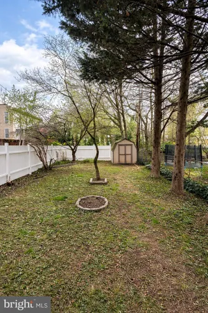 a view of a backyard with fountain plants and large trees