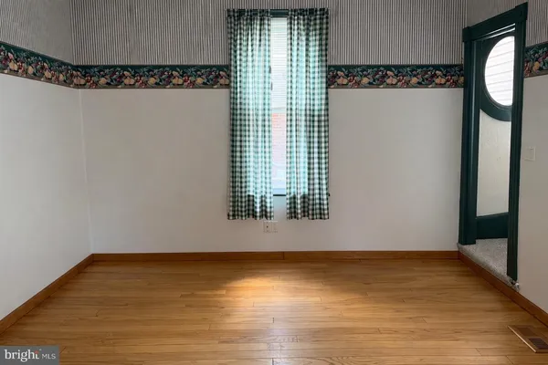 a view of walk in closet with window and wooden floor