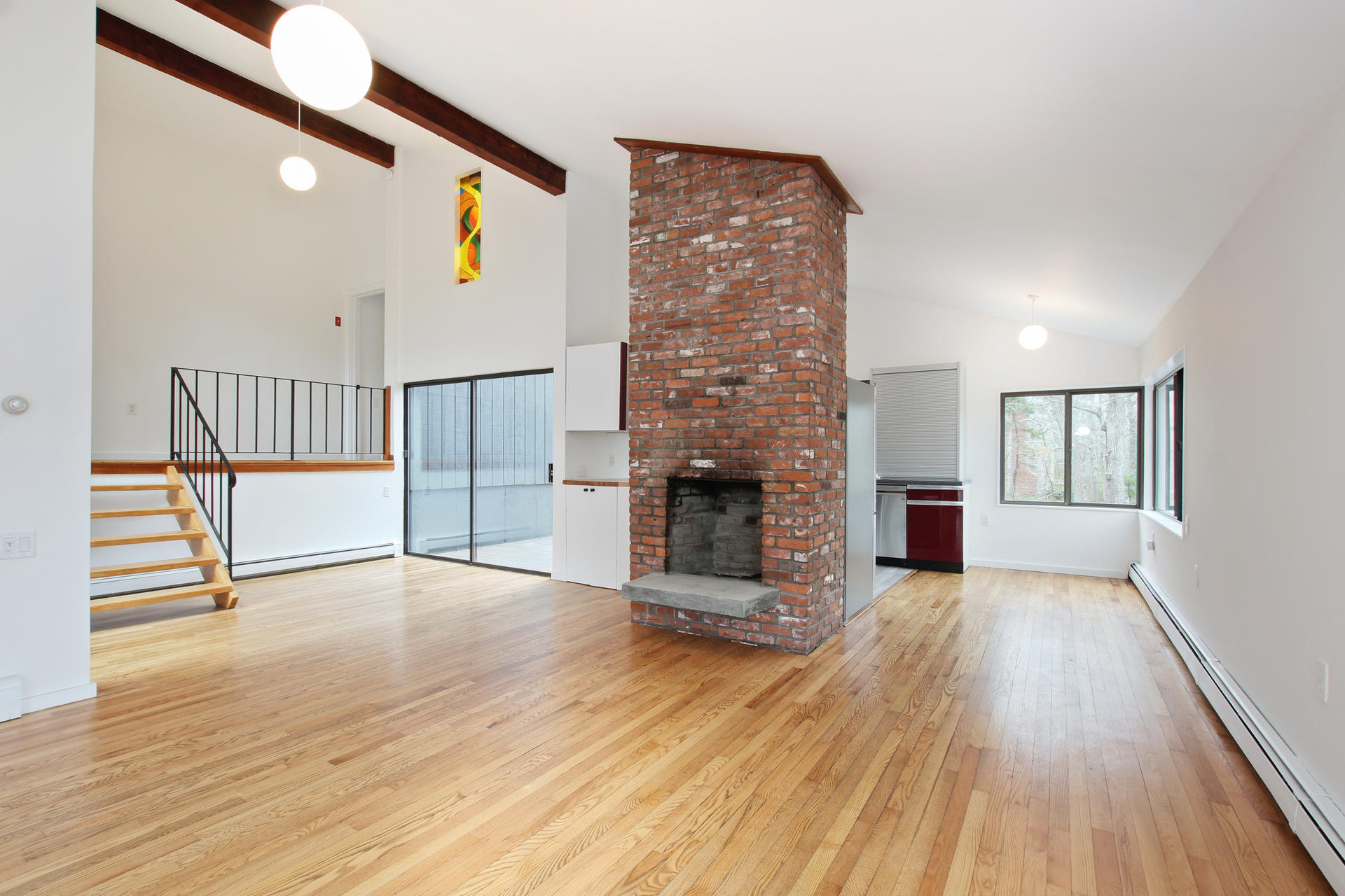 86 Upper Marsh Road Wellfleet, MA 02667 - Photo 8 of 31 a view of an empty room with wooden floor and a fireplace