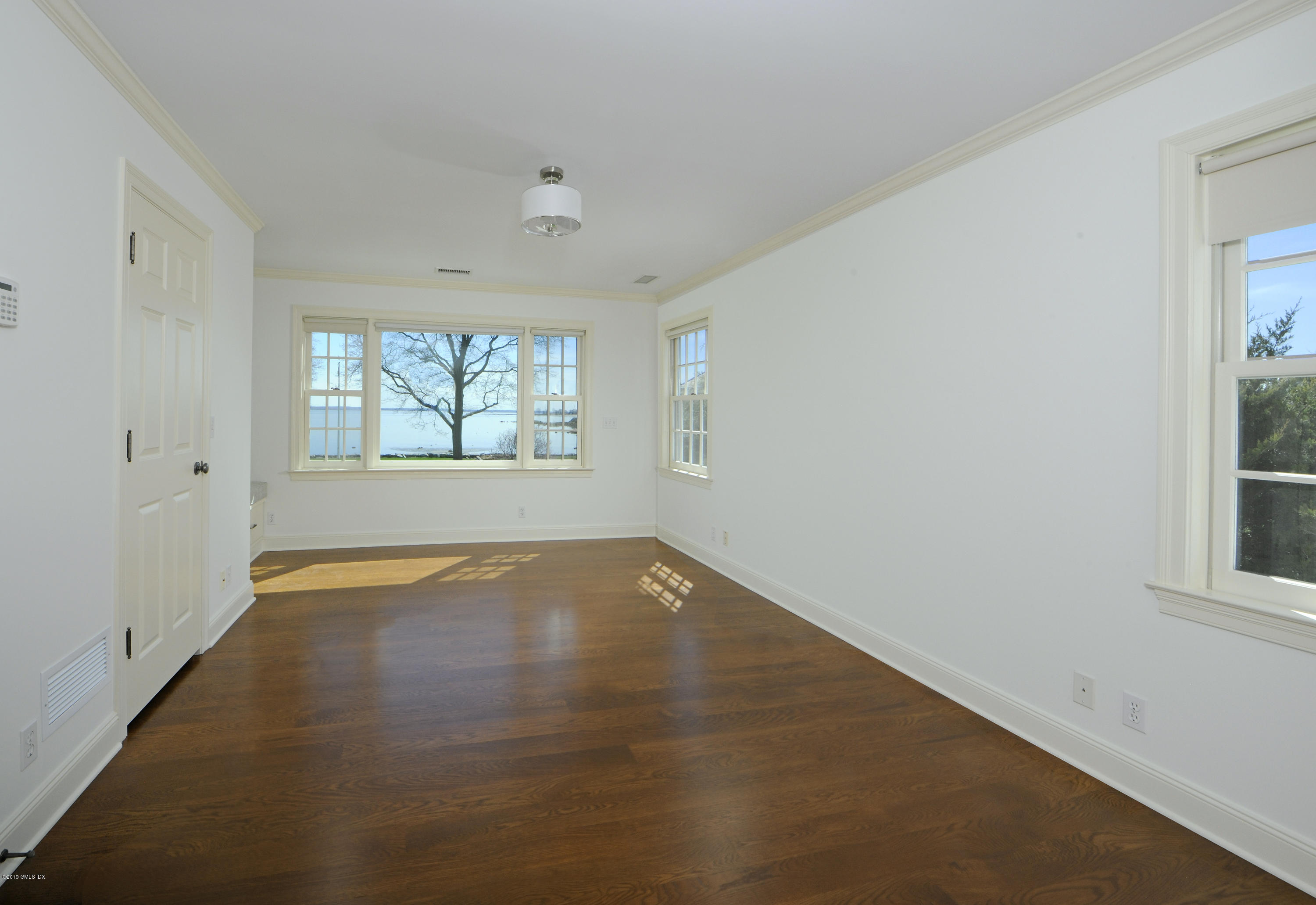 30 Rocky Point Road Old Greenwich, CT 06870 - Photo 18 of 29 an empty room with wooden floor and windows