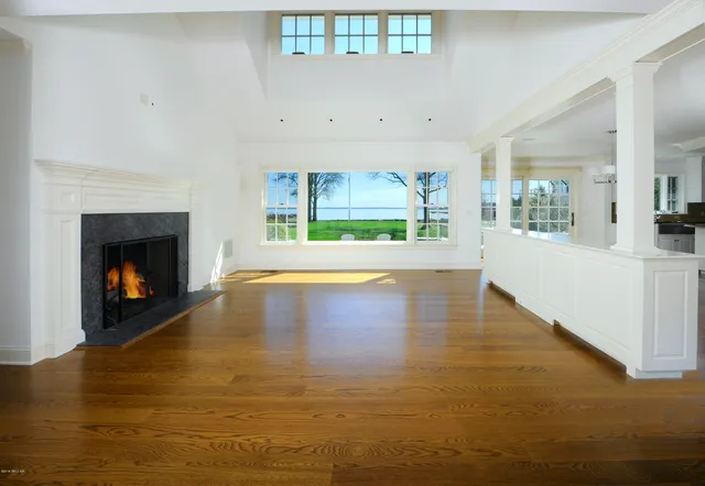 a view of an empty room with a fireplace and a window