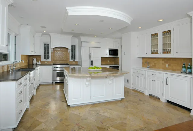 a kitchen with white cabinets and appliances