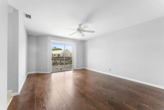 a view of a livingroom with wooden floor and a ceiling fan