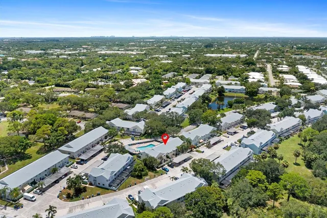 an aerial view of residential houses with outdoor space and lake view