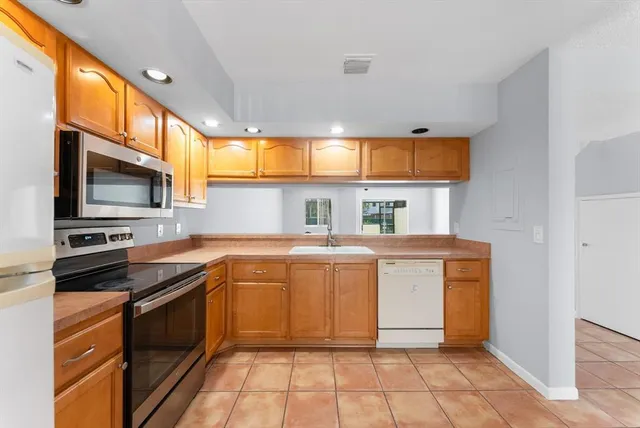 a kitchen with stainless steel appliances a stove a sink and a microwave