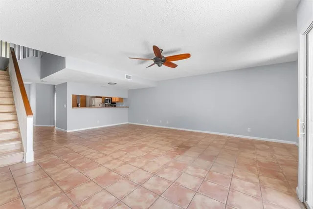 a view of a livingroom with wooden floor and a ceiling fan