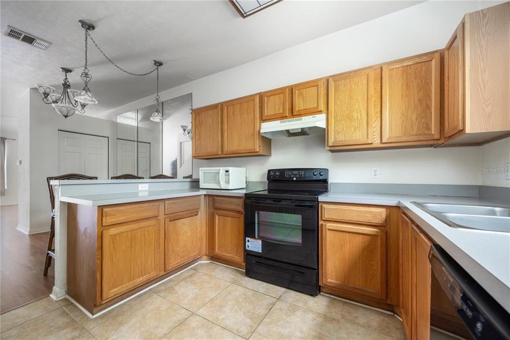 3970 Southwest 20th Avenue, Unit 909 Gainesville, FL 32607 - Photo 11 of 22 a kitchen with stainless steel appliances granite countertop a sink and cabinets